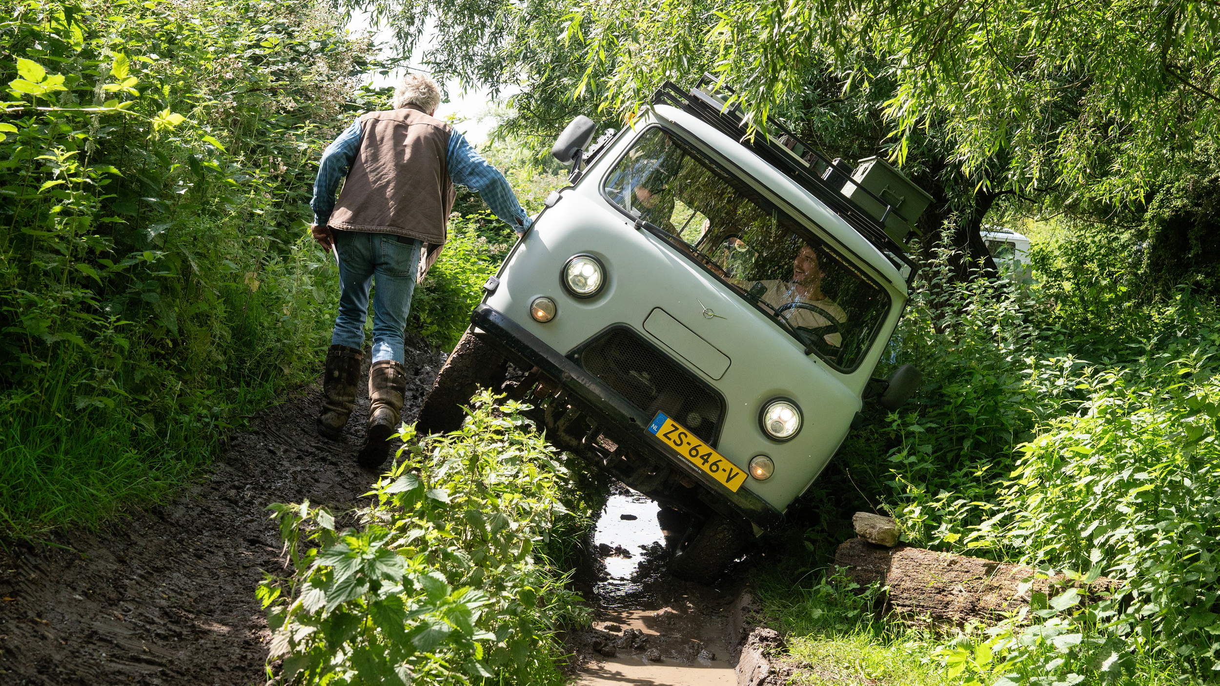 Een UAZ Bukhanka valt stil tijdens een steile side slope op het offroadterrein in het Land van Maas en Waal